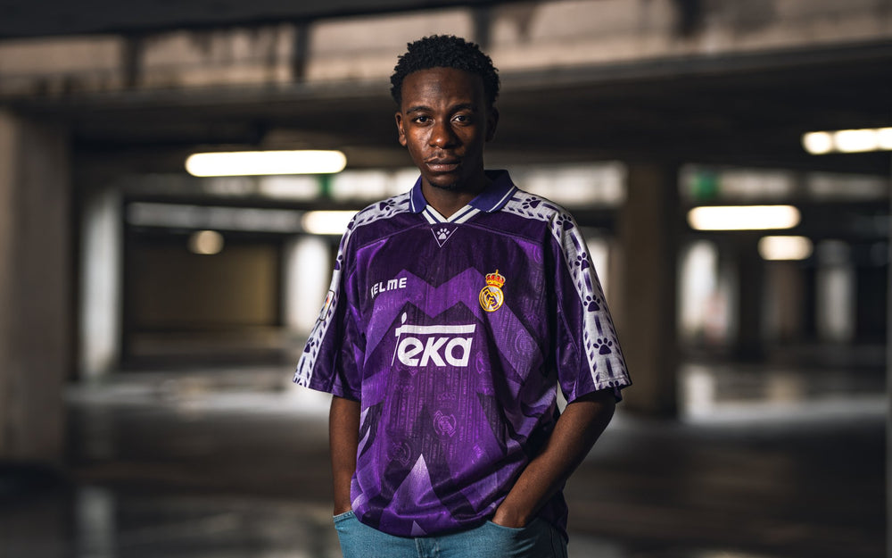 Person wearing a purple sports jersey with visible branding in an indoor setting